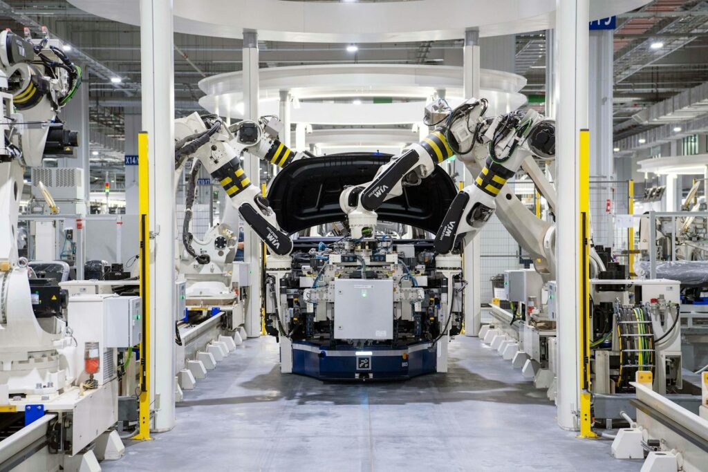 High-tech robots assembling a car in a modern factory setting, showcasing automation.